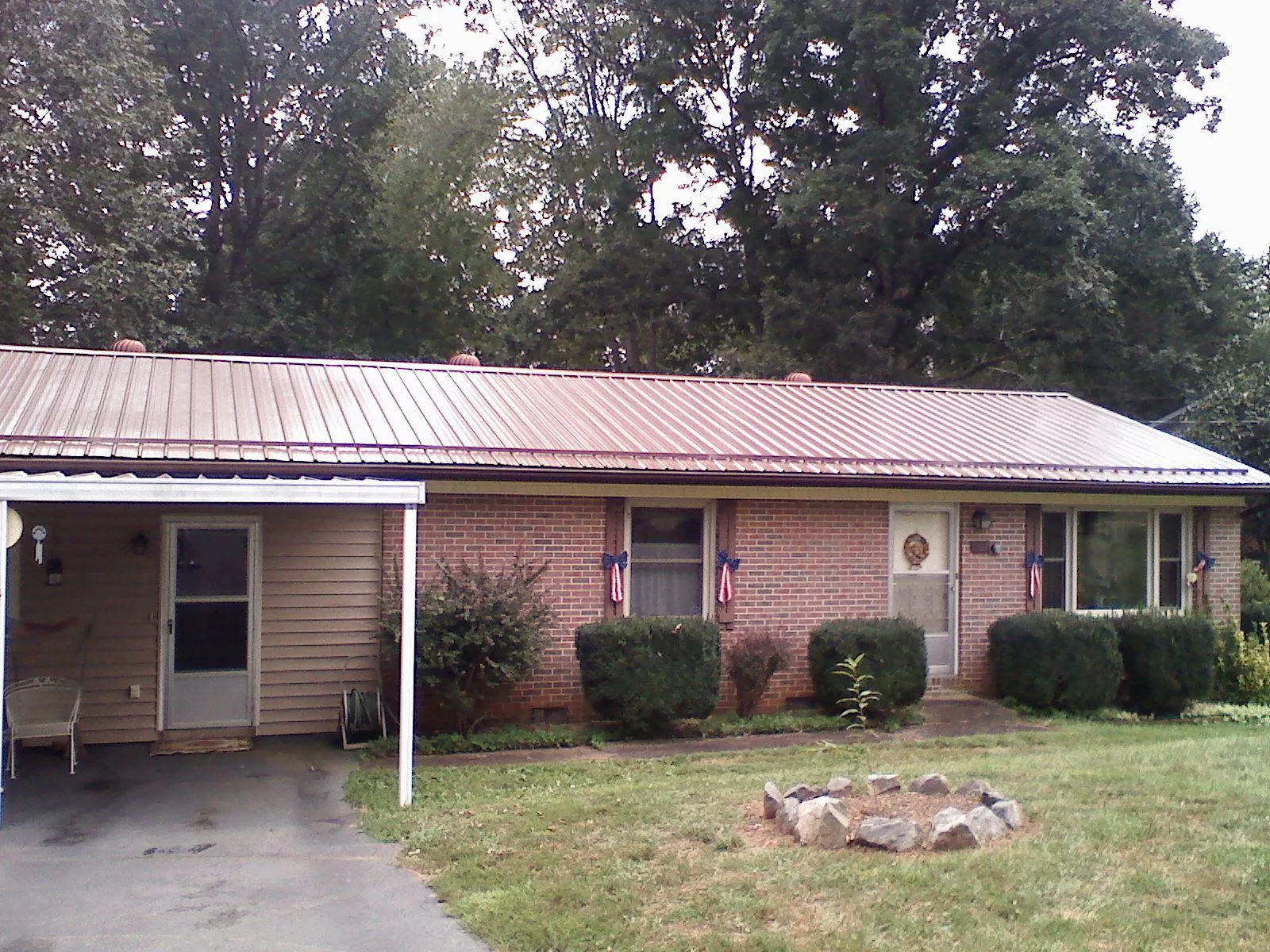 Bronze metal roof and carport on a brick ranch home — Roof Repair work by our crew in Seabrook